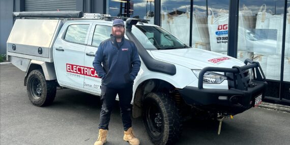 Isaac in front of South Island Electrical ute