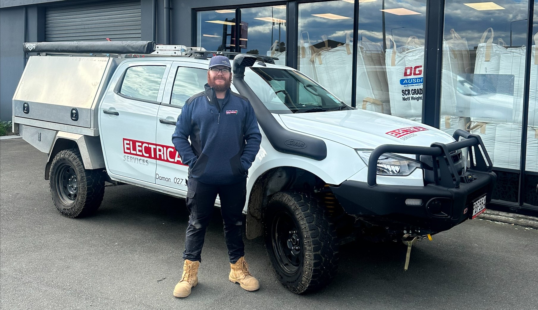 Isaac in front of South Island Electrical ute